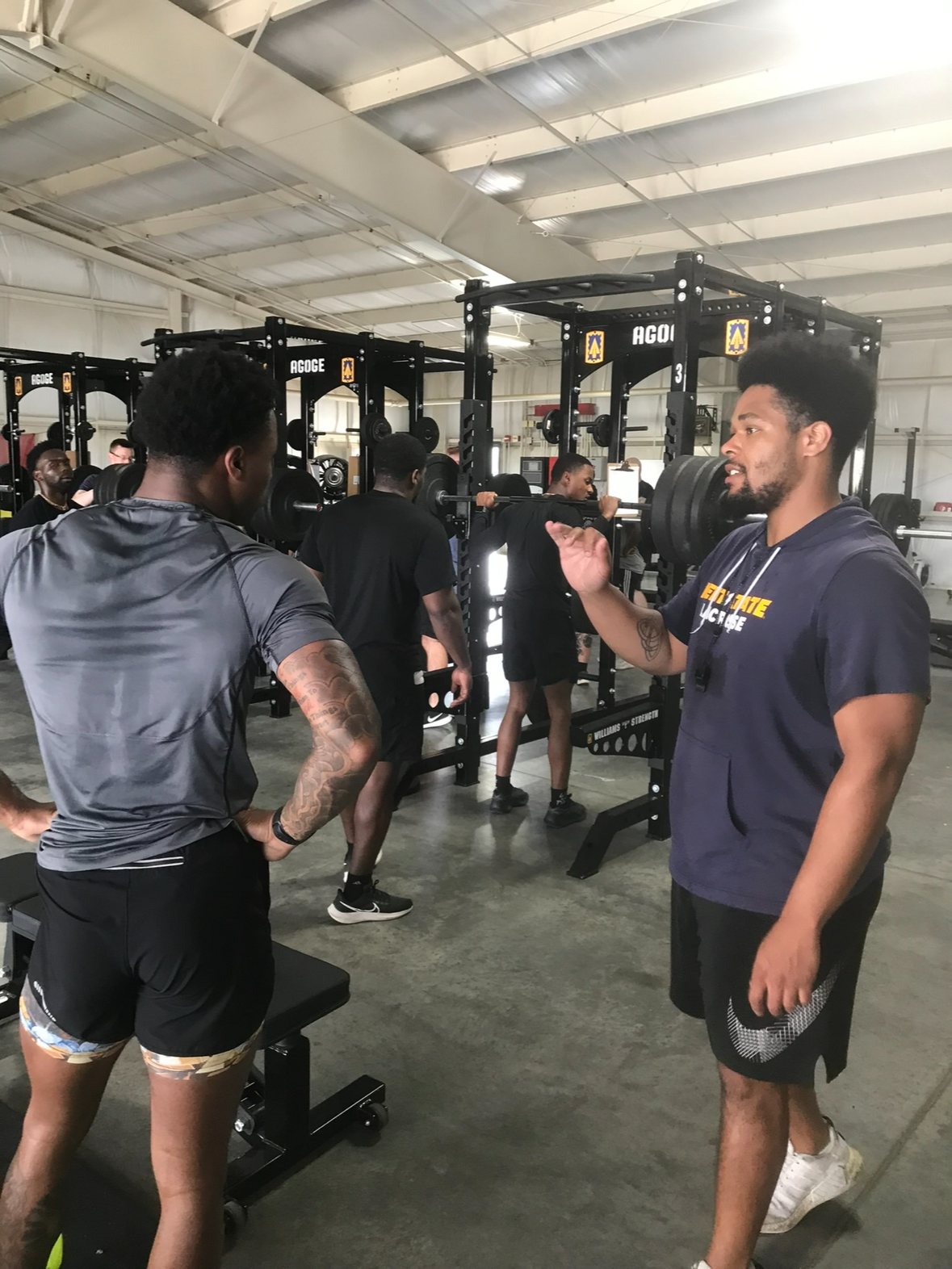 Laron Allen coaching an athlete on the weight-room floor